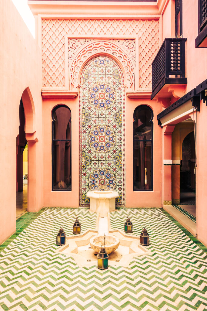 Décoration intérieure de style marocain avec fontaine et filtre vintage, mettant en valeur des éléments architecturaux et décoratifs inspirés du Maroc.